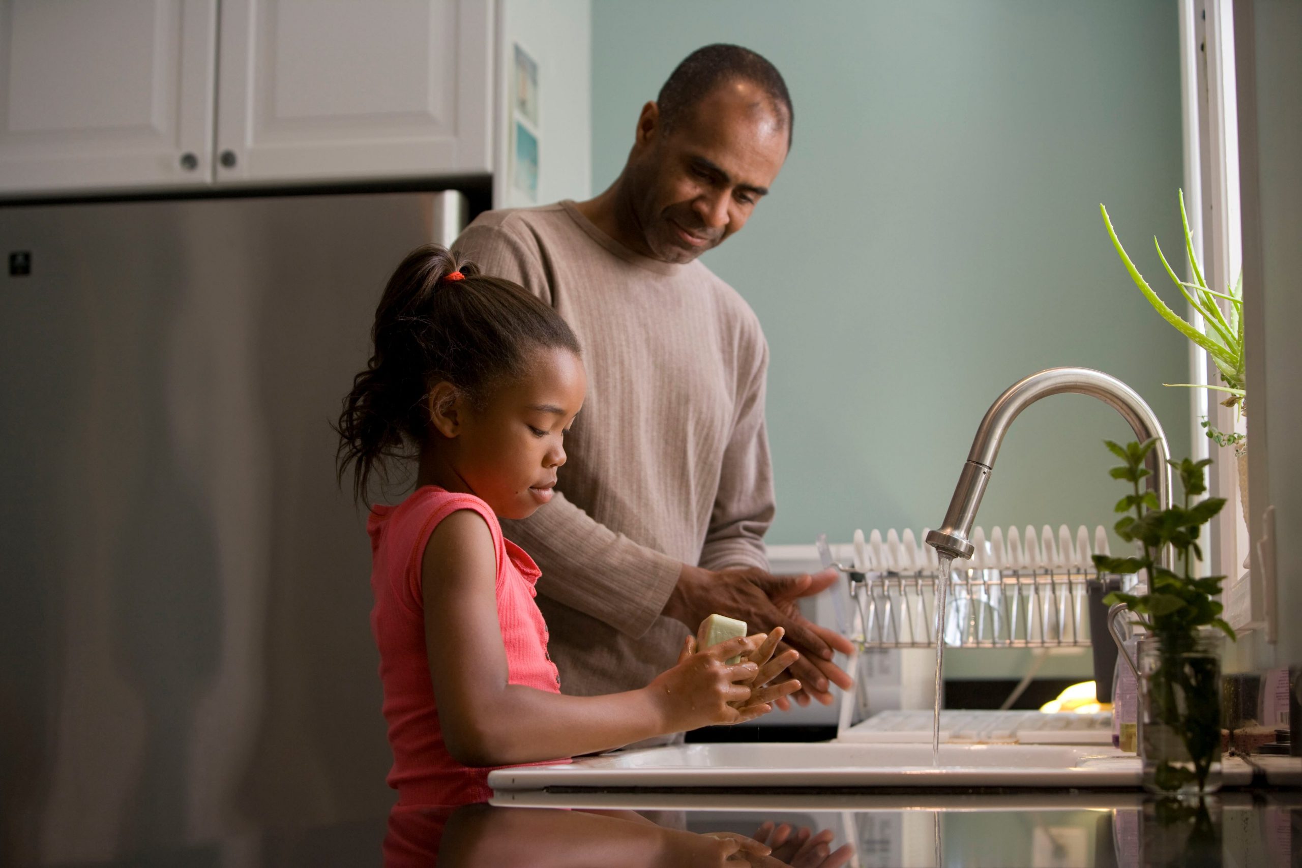 parent and child washing dishes